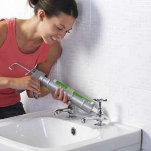 woman caulking sink