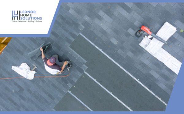 handyman placing roofing materials on house roof