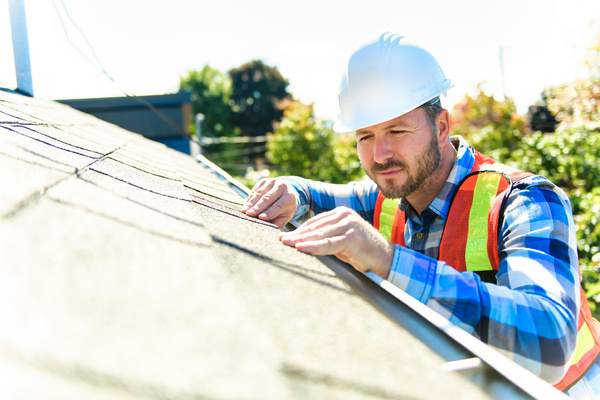 handyman preparing house roof for the summer