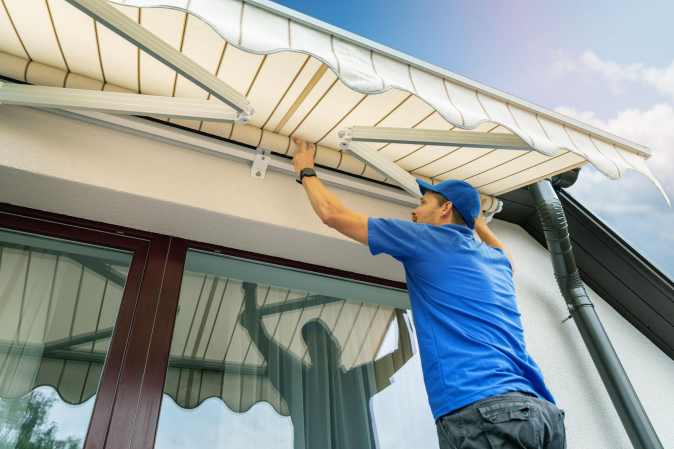 man installing a white awning in a house