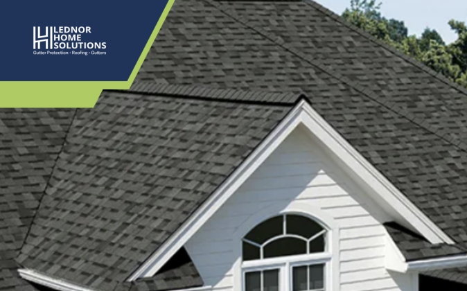  Dark shingled roof with gable and window.